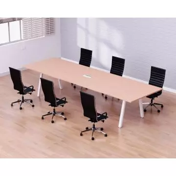 Modern conference room with a long wooden table and six black ergonomic office chairs on a light wood floor.