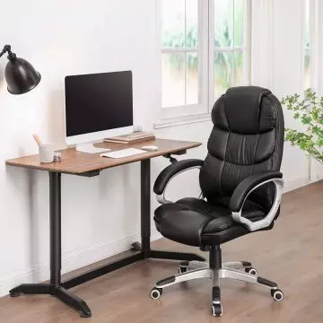 Black high back PU leather office chair beside desk in home office