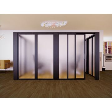 Black-framed frosted glass sliding partition in a modern room with wooden flooring and contemporary furniture.