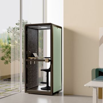 Soundproof phone pod with black frame and green side panel in office corner