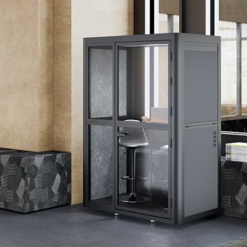 Black frame phone pod with glass door and built in desk in office