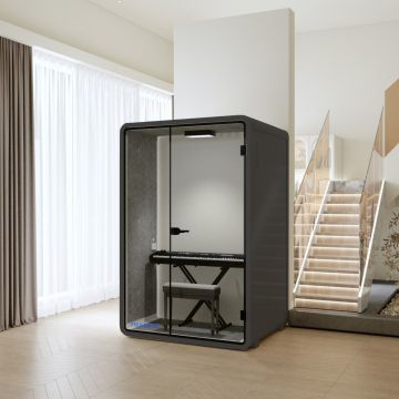 Soundproof phone pod with glass door and keyboard setup in modern home