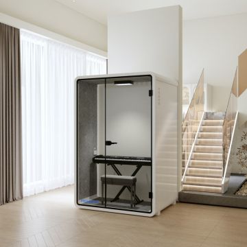 White framed soundproof pod with glass door and keyboard setup