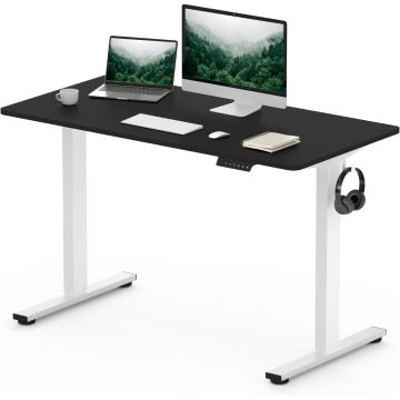 Black and white adjustable standing desk with a laptop  monitor  keyboard  mouse  notebook  cup  and headphones hanging on the side.