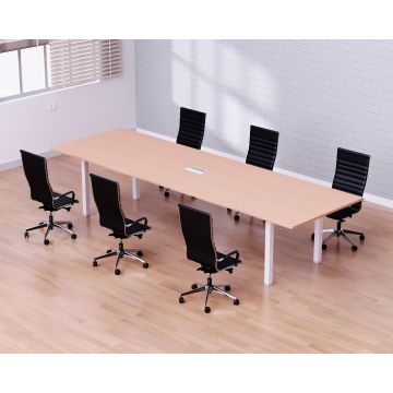 long oak conference table with white legs and six black chairs in bright office