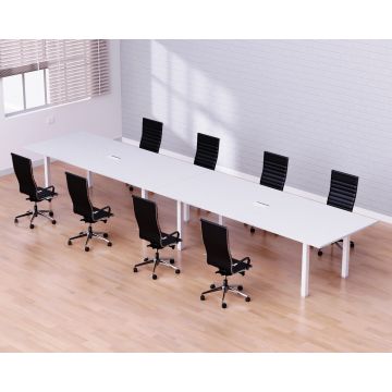 Long white conference table with black office chairs in a bright meeting room